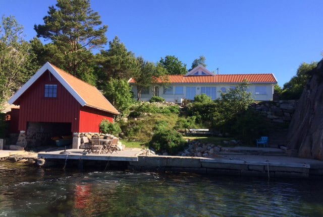 Restaurert rødt naust ved sjøen